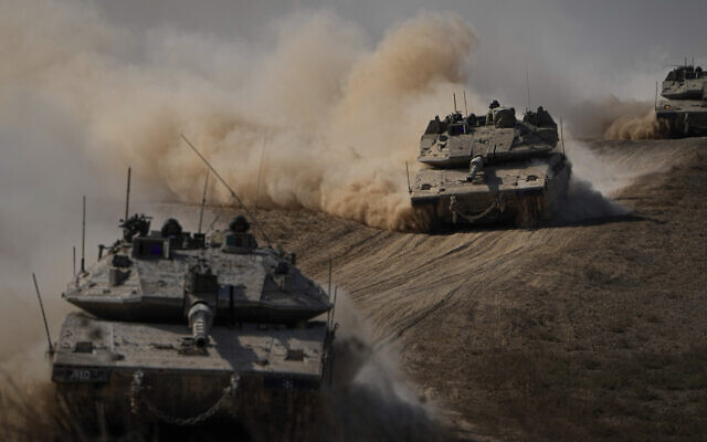 Israeli tanks head towards the Gaza Strip border in southern Israel on Friday, Oct.13, 2023. (AP Photo/Ariel Schalit)